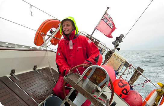 Windage - Anchor Load | A lady sailor steering the boat's gear